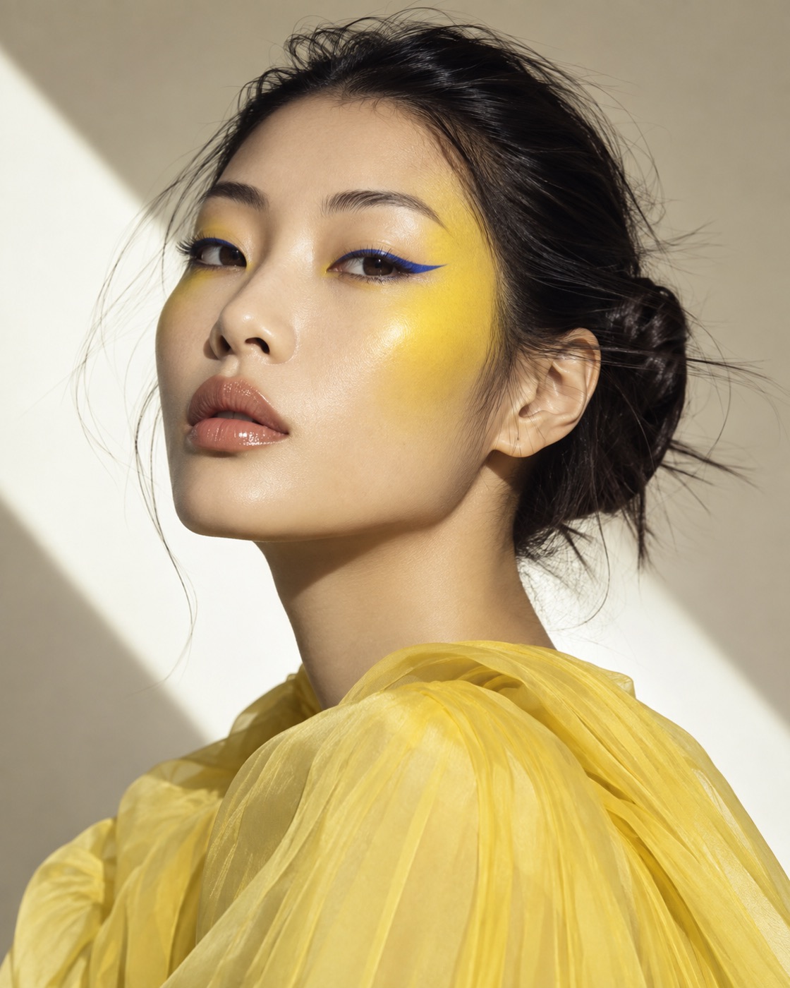 Editorial beauty portrait with cobalt and yellow graphic makeup